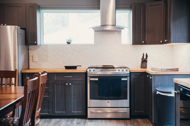 Dark shaker kitchen cabinets with aligned drawer fronts, doors, and metal hardware