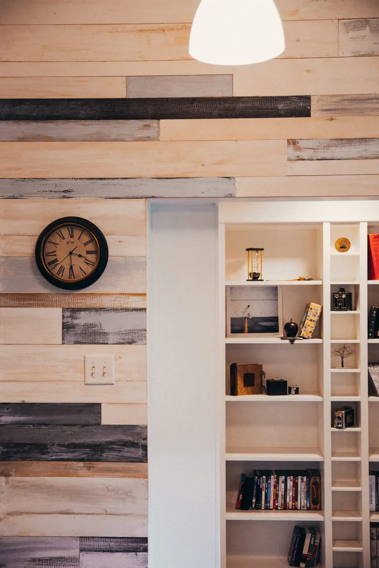 Custom built-in shelving set into a warm wood-panelled interior wall